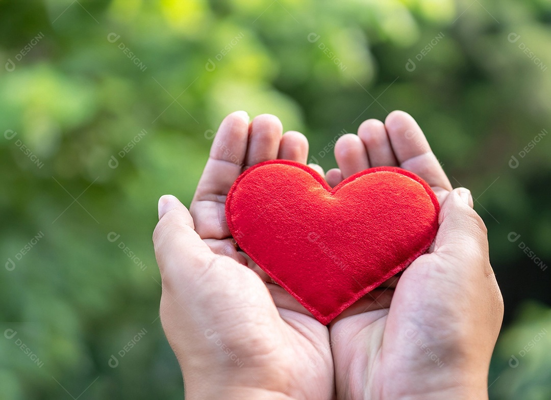 Mãos segurando um coração vermelho