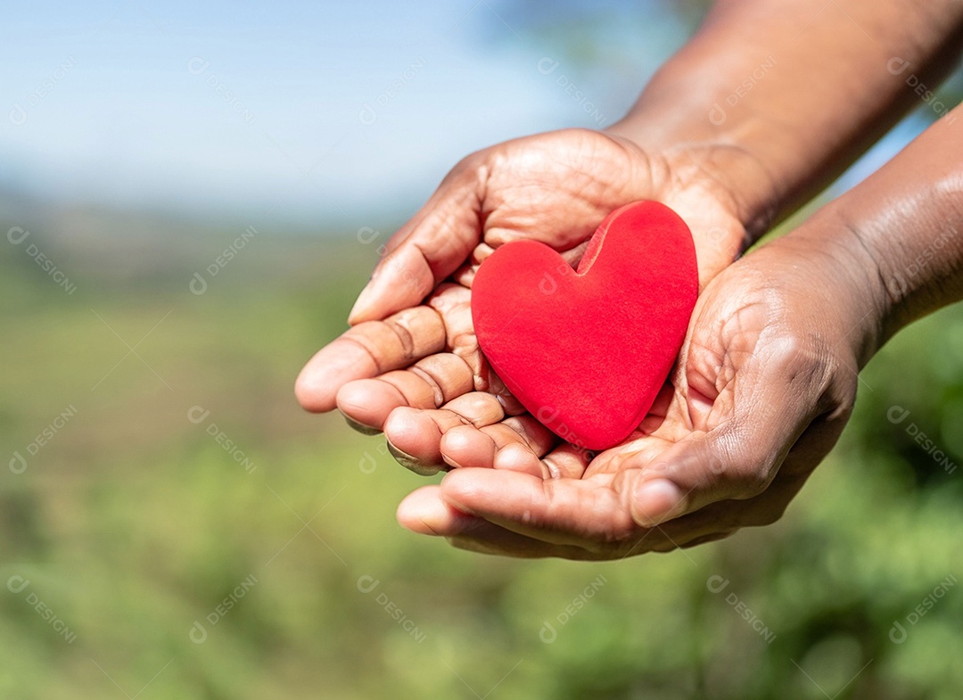 Mãos segurando um coração vermelho