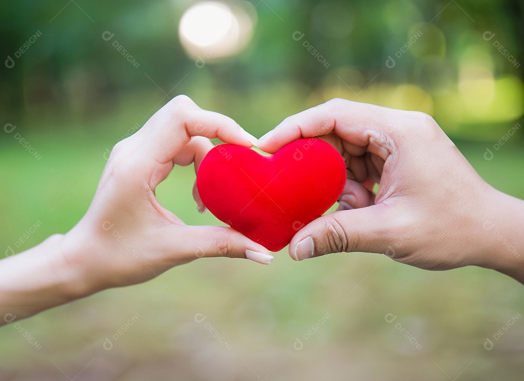 Mãos segurando um coração vermelho