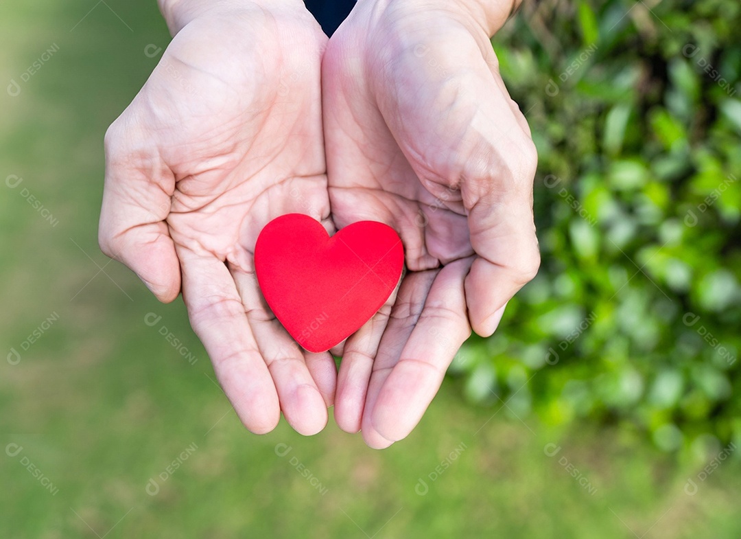 Mãos segurando um coração vermelho