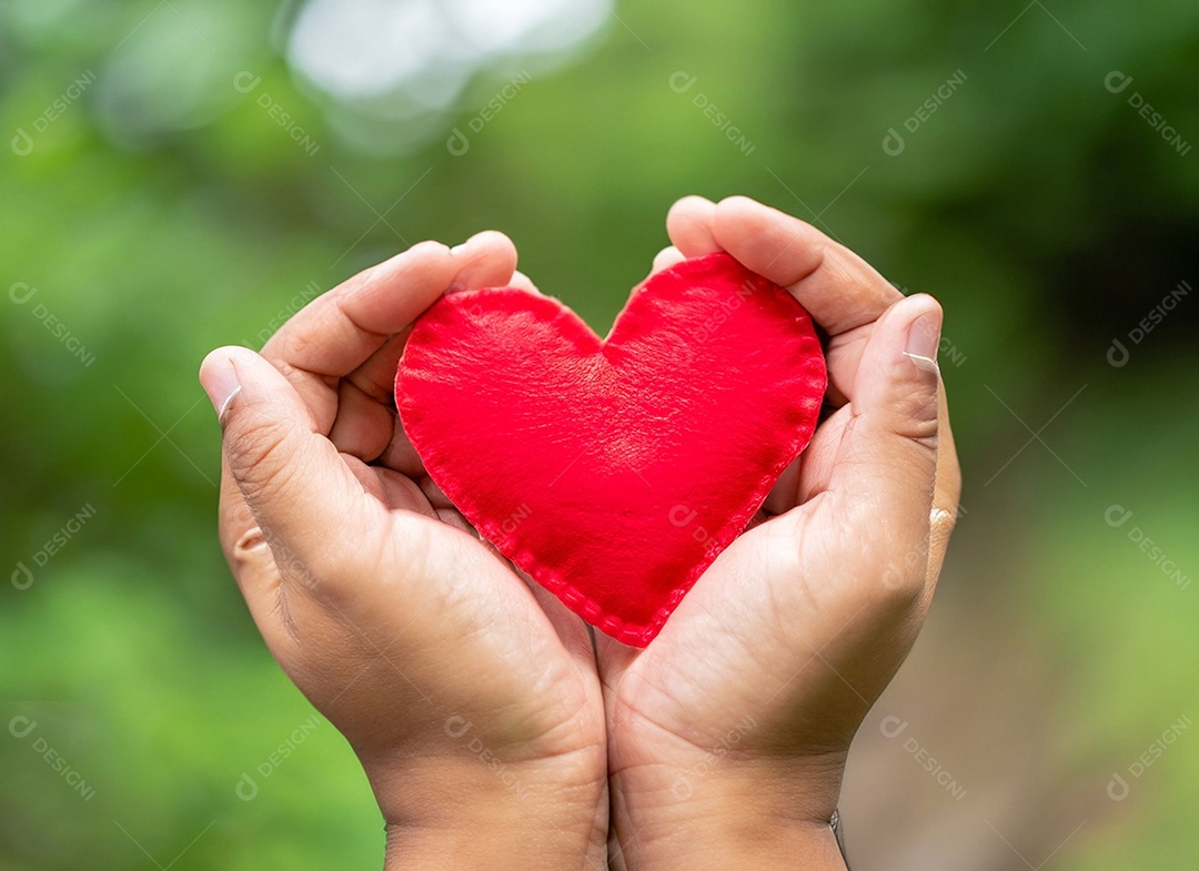 Mãos segurando um coração vermelho
