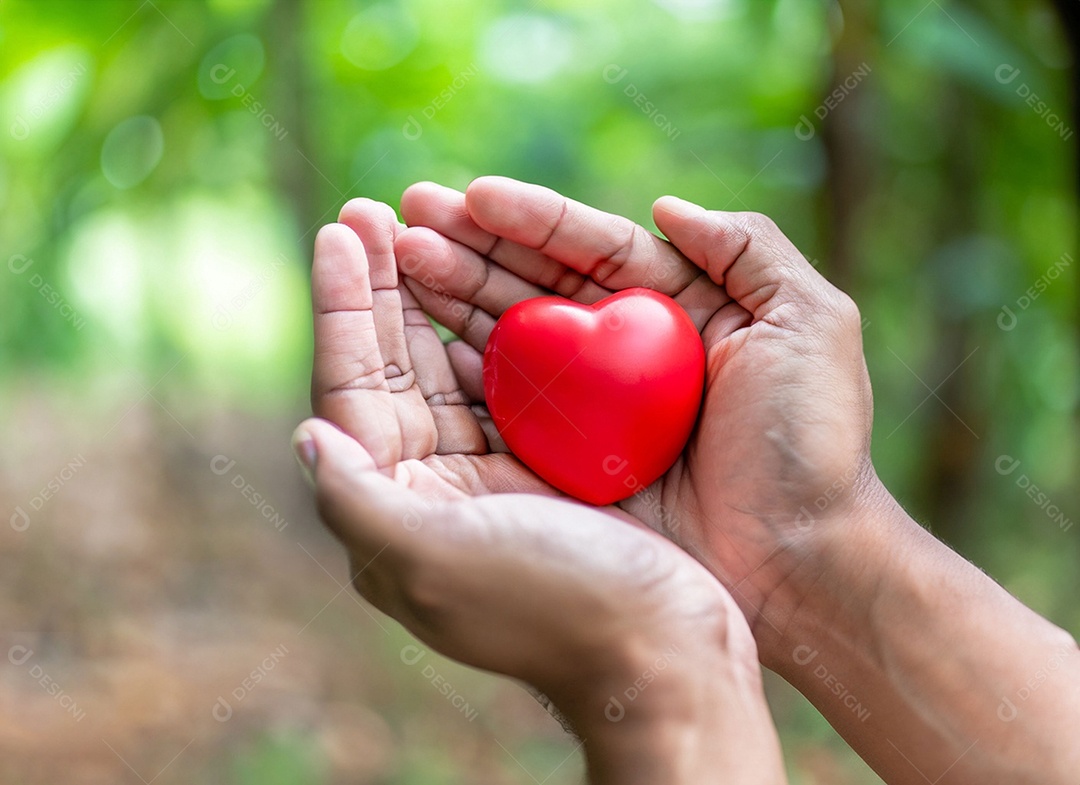 Mãos segurando um coração vermelho