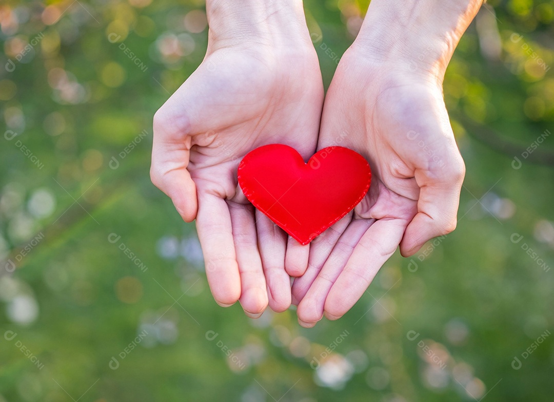 Mãos segurando um coração vermelho