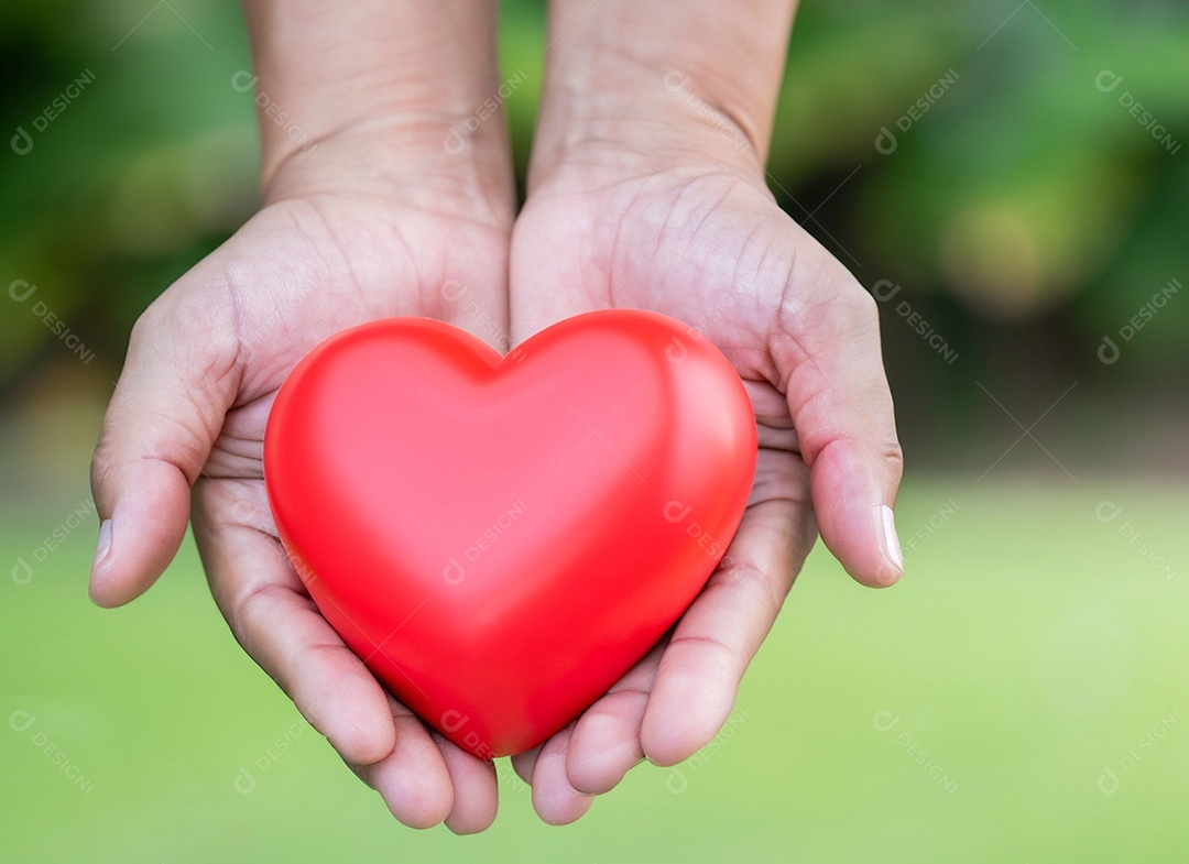 Mãos segurando um coração vermelho