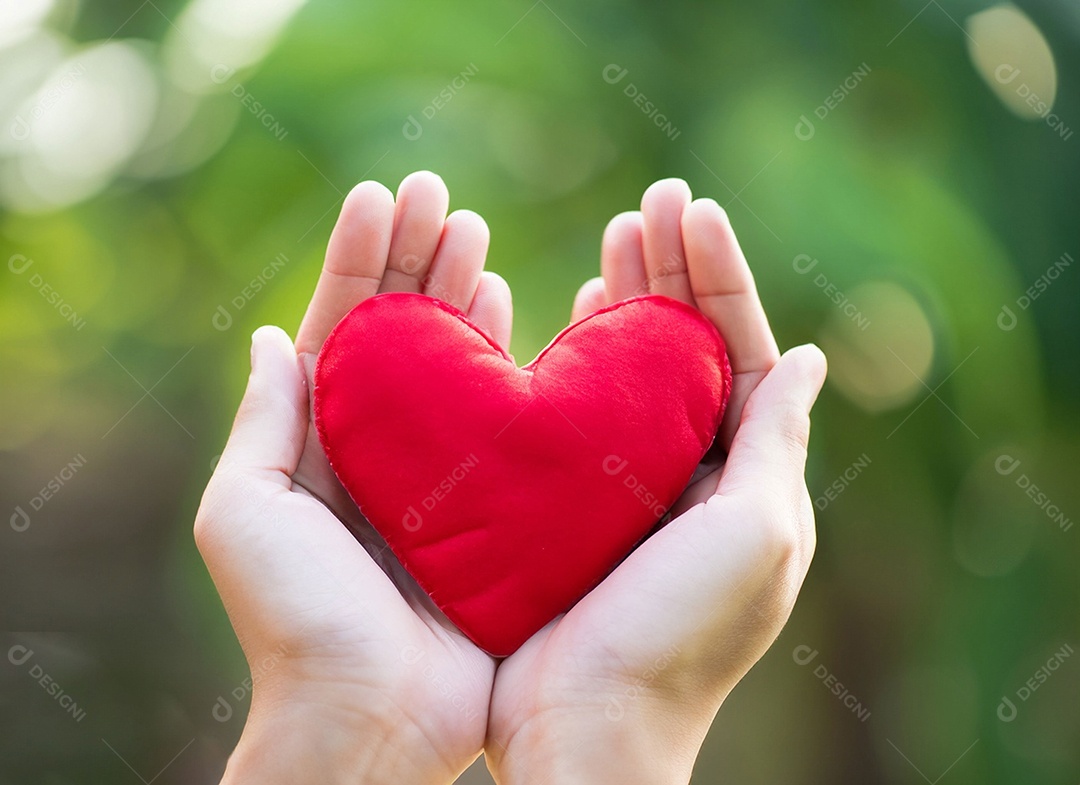 Mãos segurando um coração vermelho