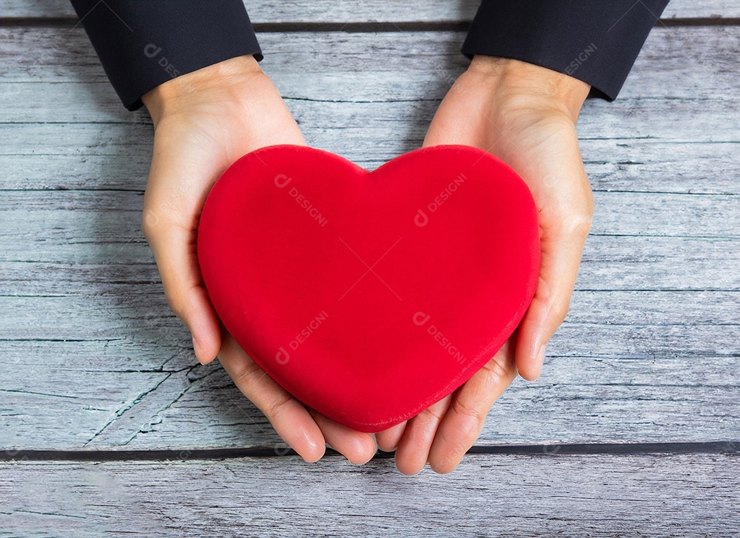 Mãos segurando um coração vermelho