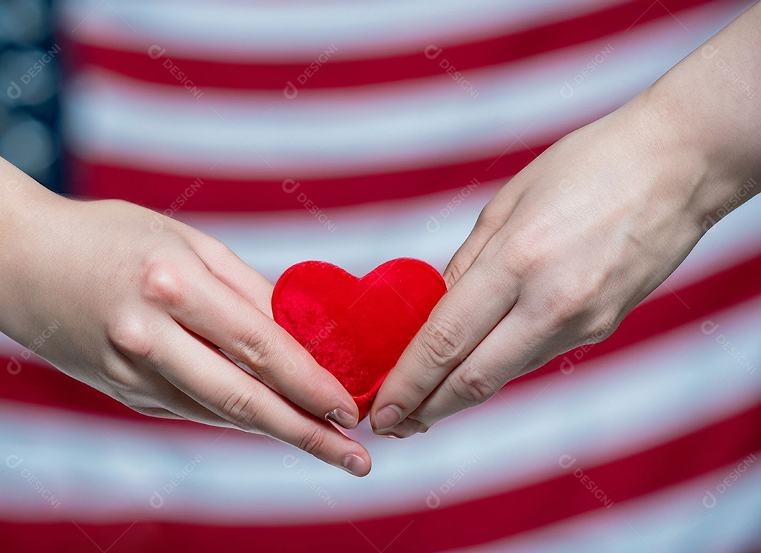 Mãos segurando um coração vermelho