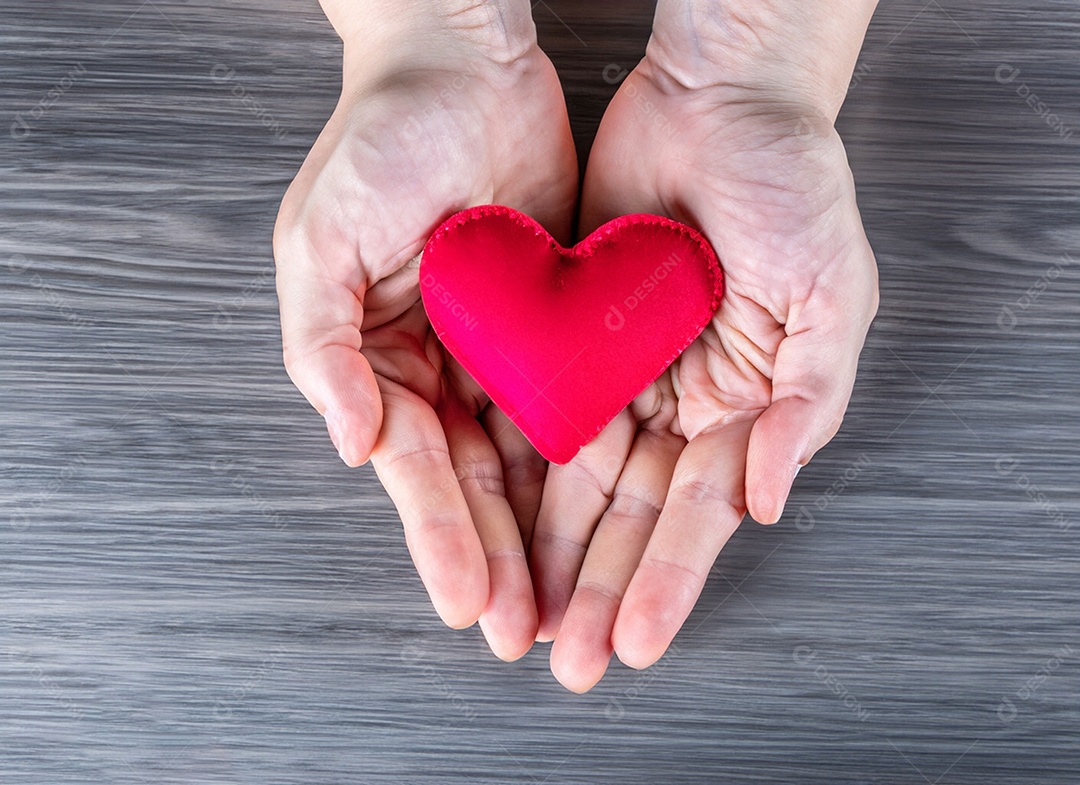 Mãos segurando um coração vermelho