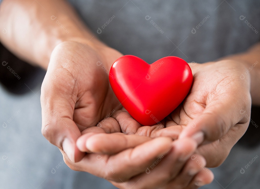 Mãos segurando um coração vermelho