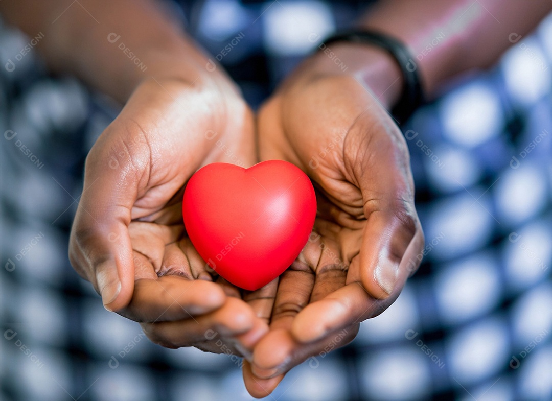 Mãos segurando um coração vermelho