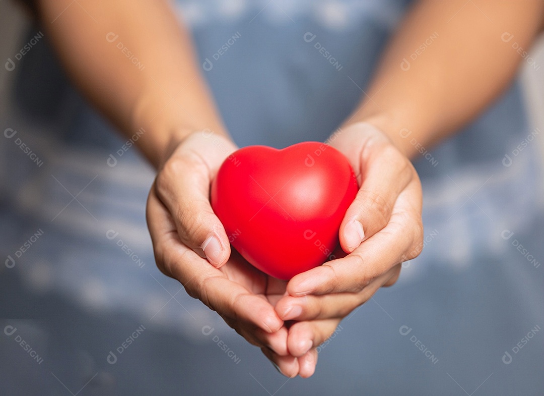 Mãos segurando um coração vermelho