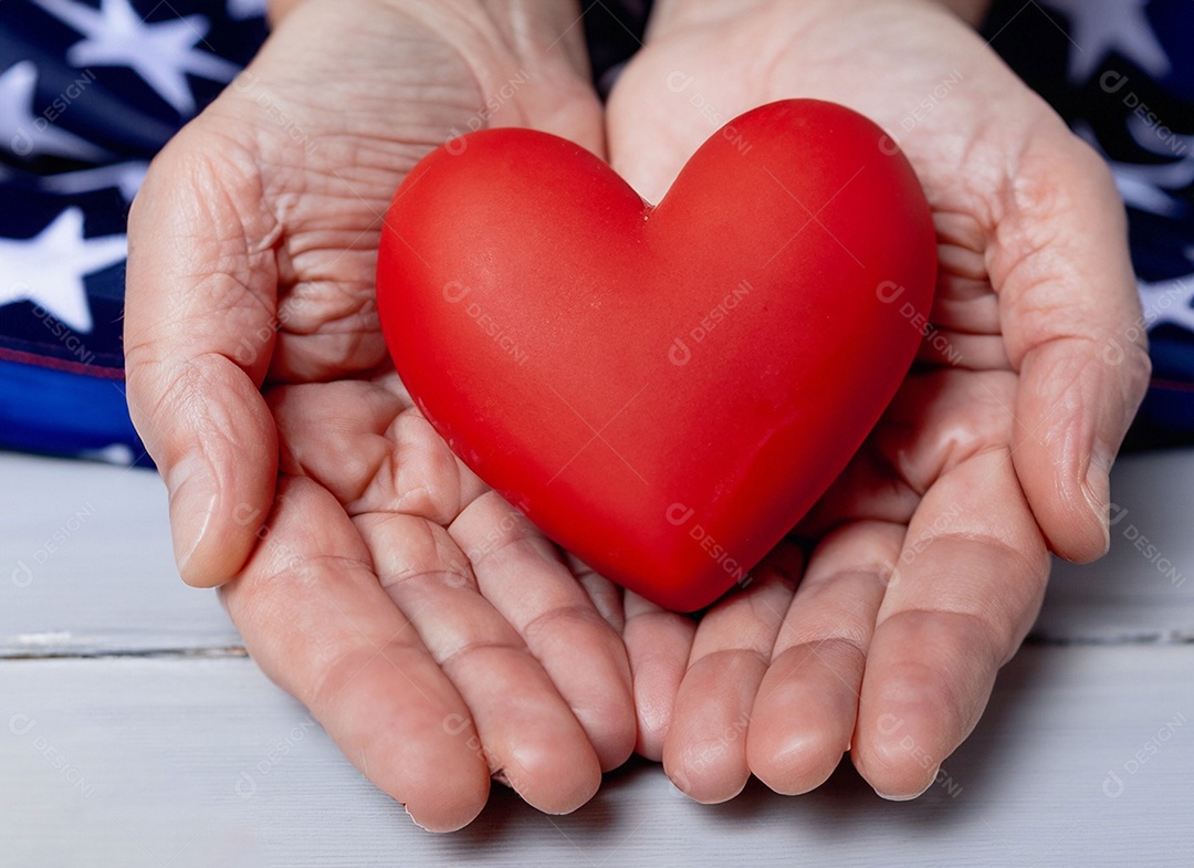 Mãos segurando um coração vermelho