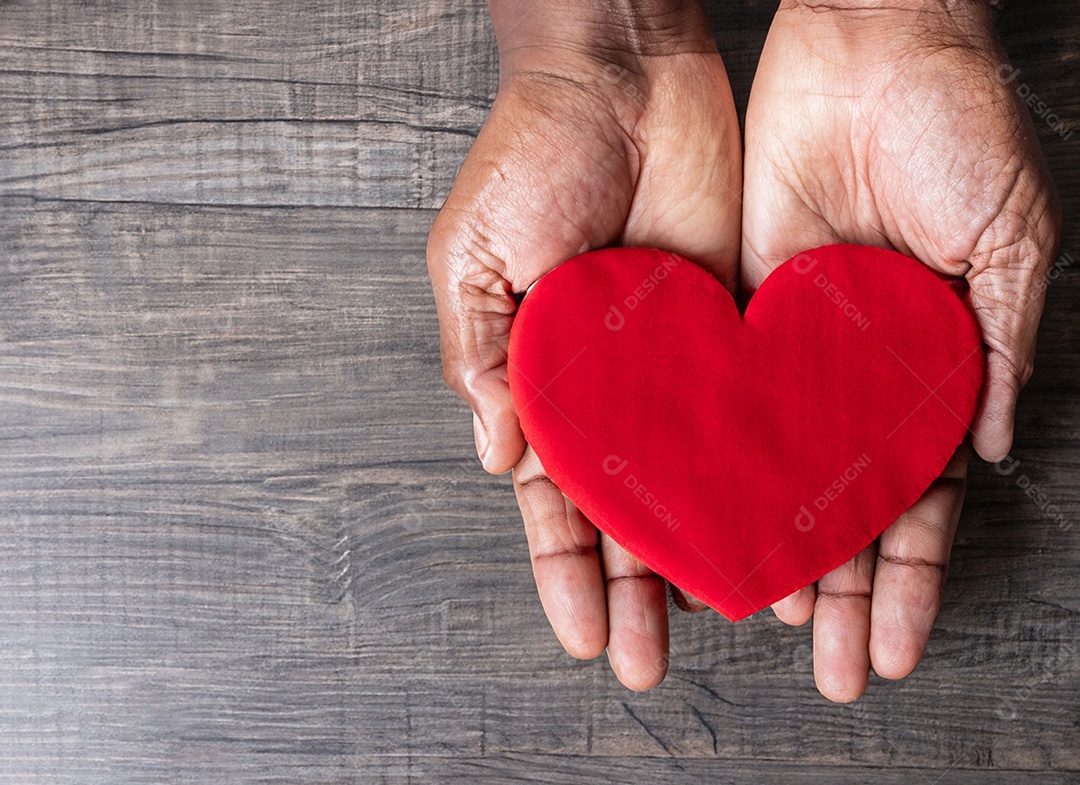 Mãos segurando um coração vermelho
