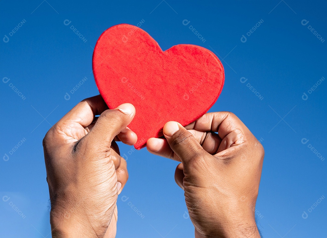 Mãos segurando um coração vermelho