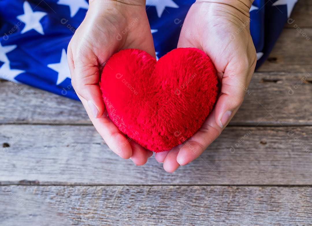 Mãos segurando um coração vermelho