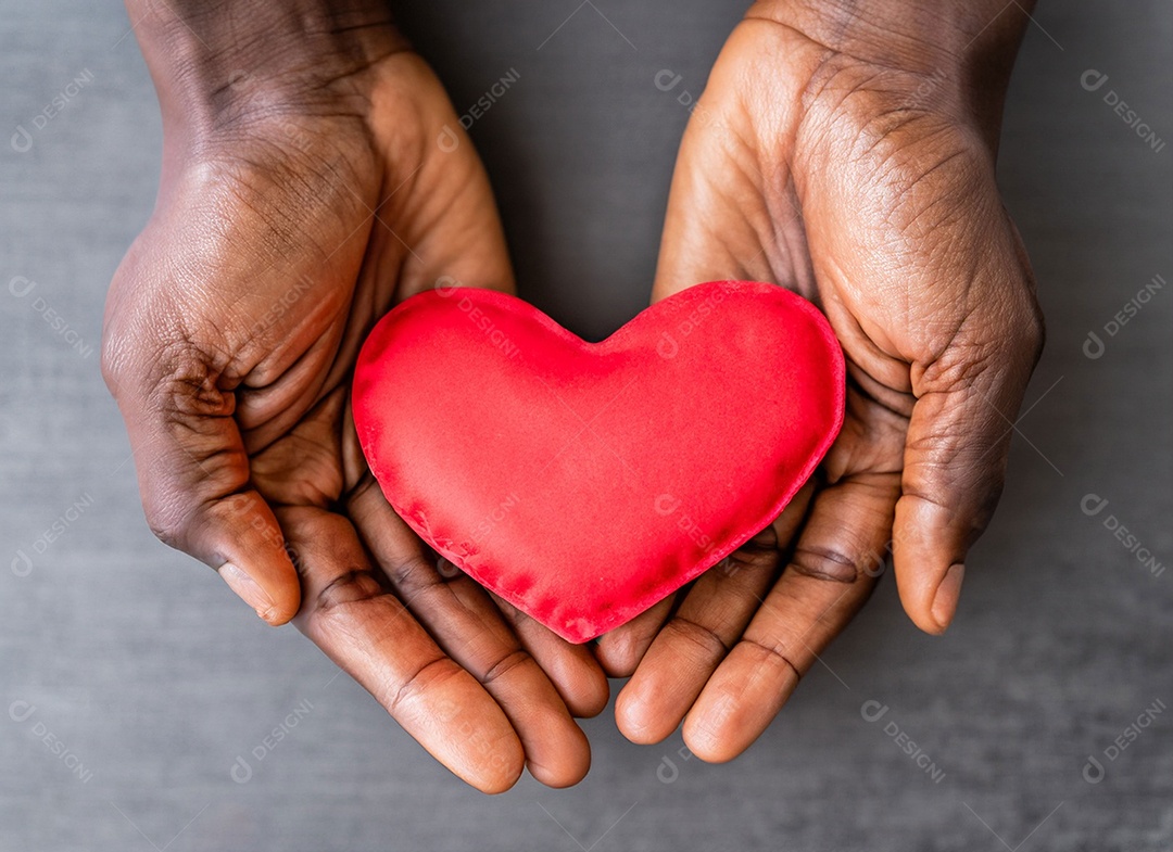 Mãos segurando um coração vermelho