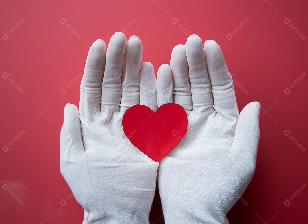 Mãos segurando um coração vermelho