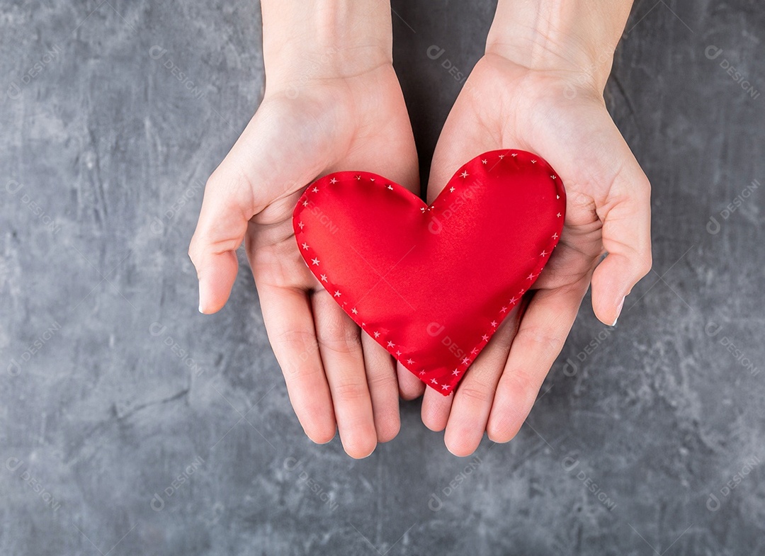 Mãos segurando um coração vermelho