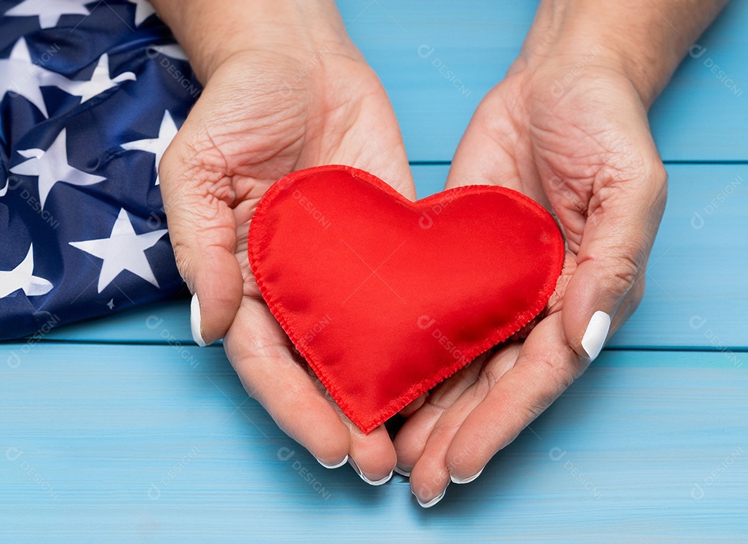 Mãos segurando um coração vermelho