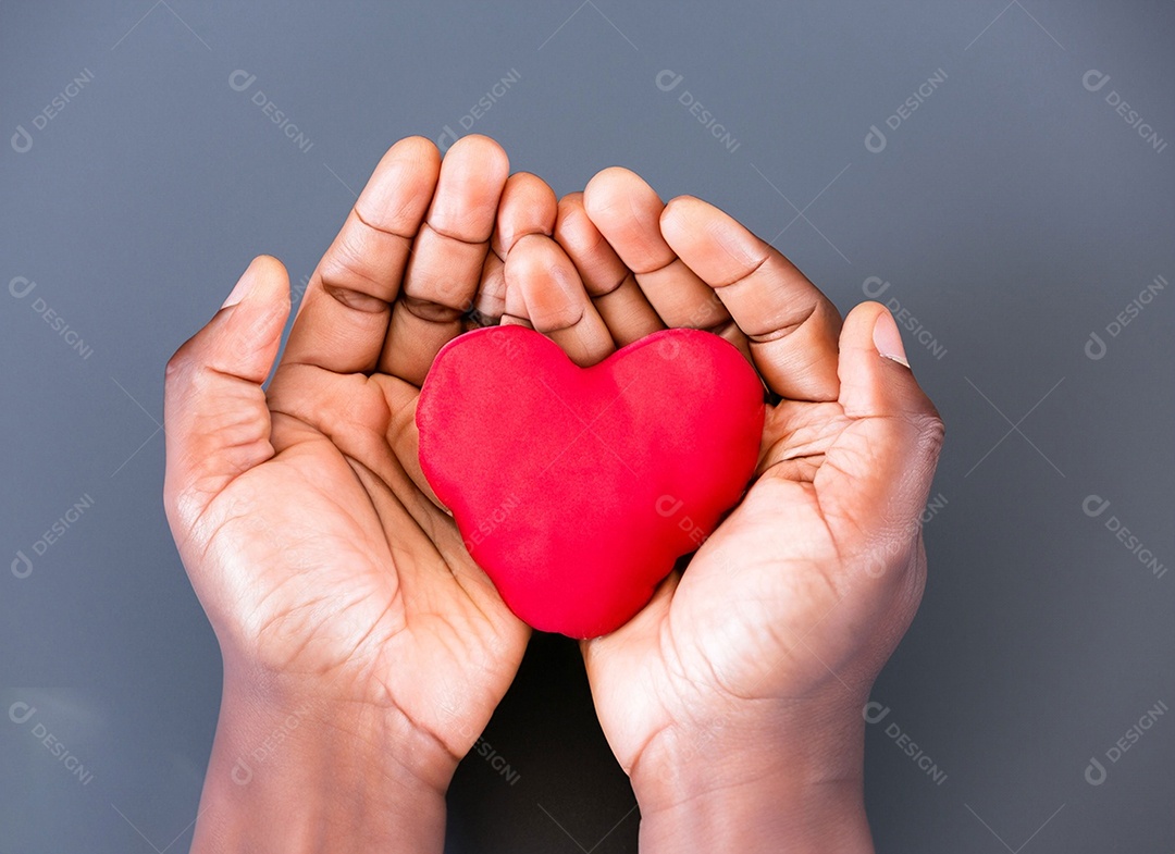 Mãos segurando um coração vermelho