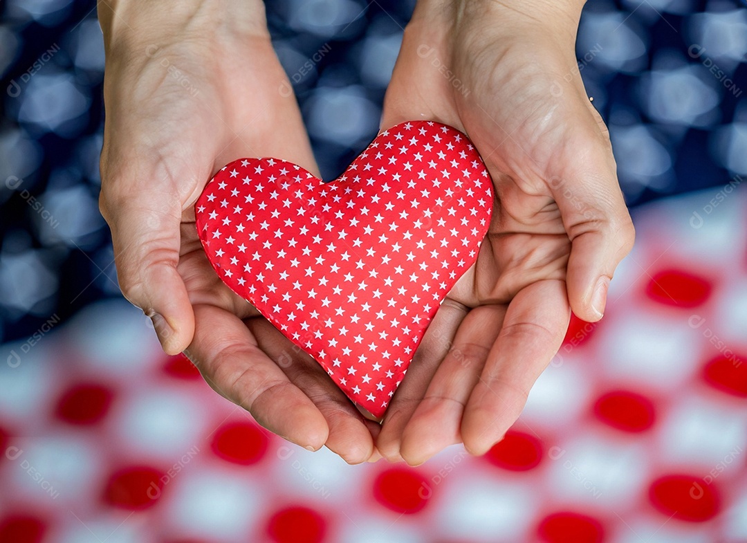 Mãos segurando um coração vermelho