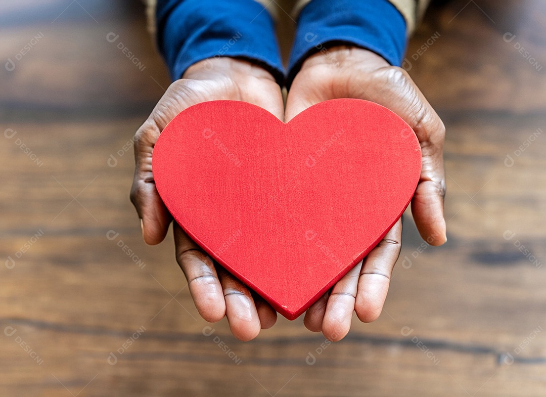 Mãos segurando um coração vermelho