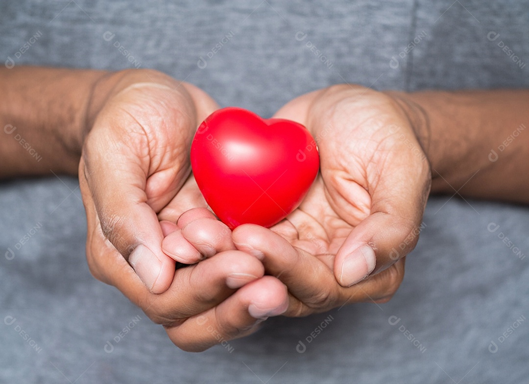 Mãos segurando um coração vermelho