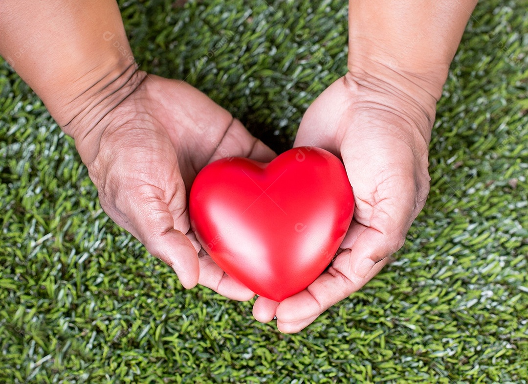 Mãos segurando um coração vermelho