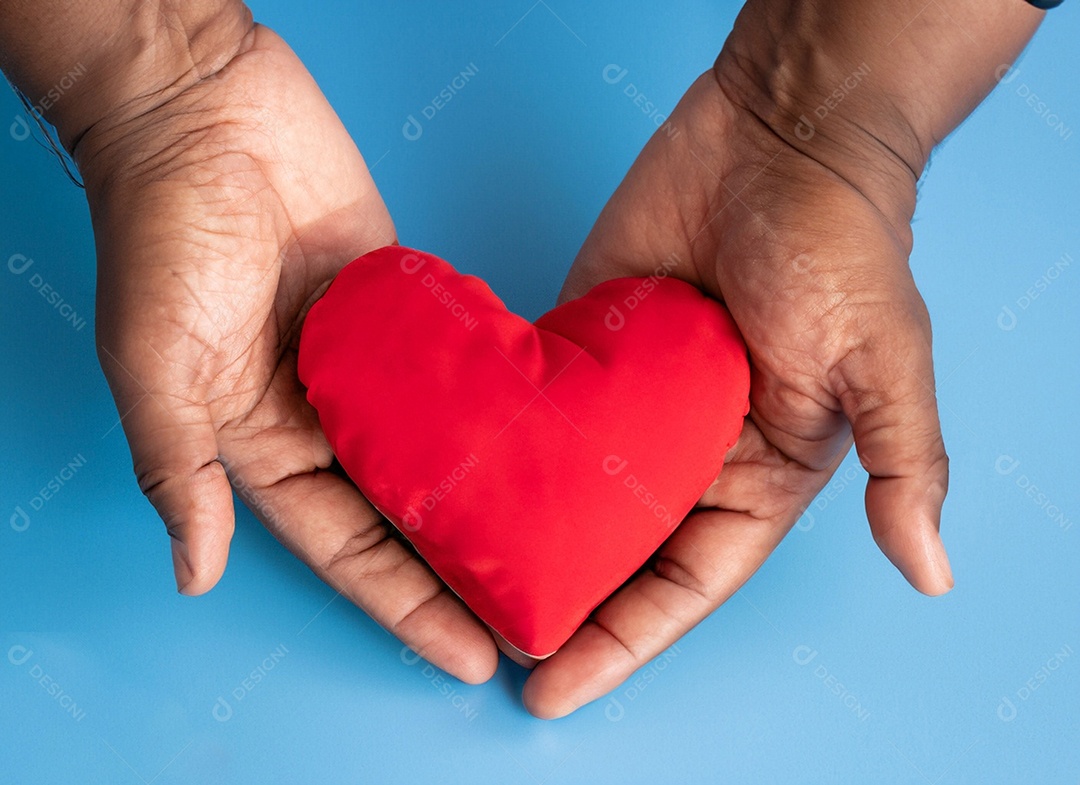 Mãos segurando um coração vermelho