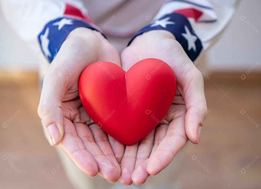 Mãos segurando um coração vermelho