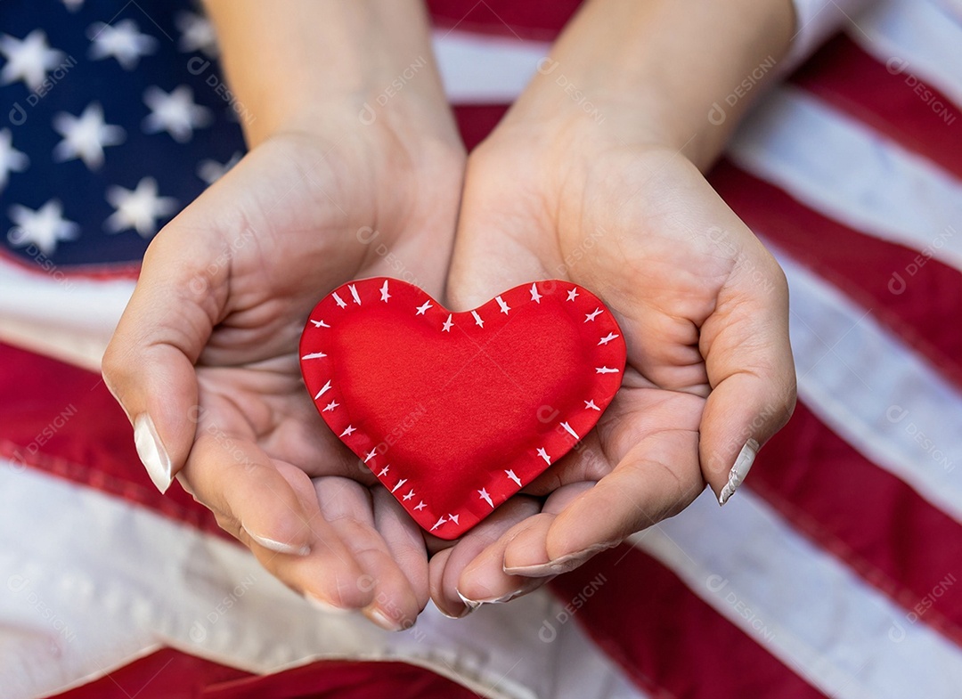 Mãos segurando um coração vermelho