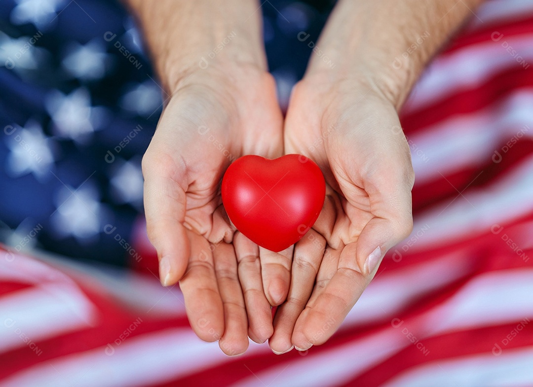 Mãos segurando um coração vermelho