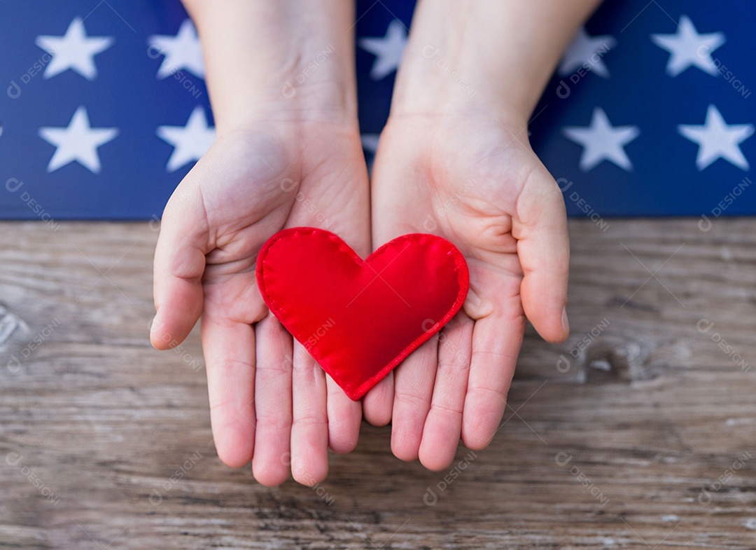 Mãos segurando um coração vermelho