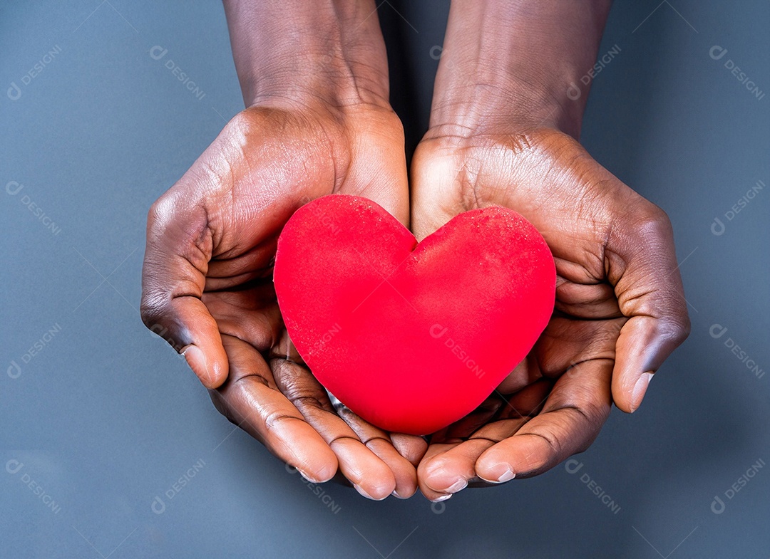 Mãos segurando um coração vermelho