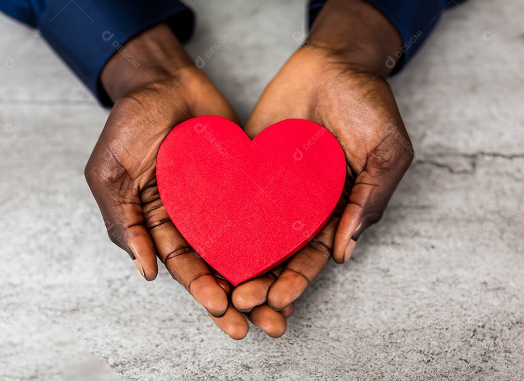 Mãos segurando um coração vermelho