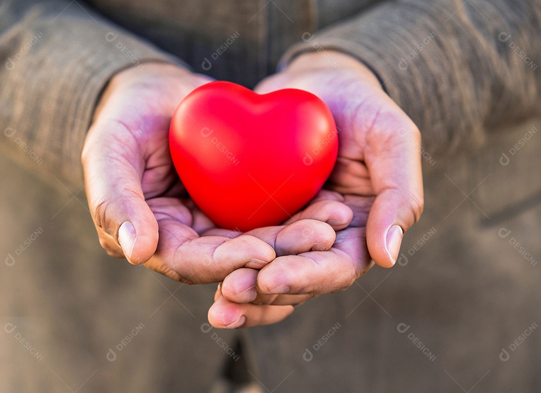 Mãos segurando um coração vermelho
