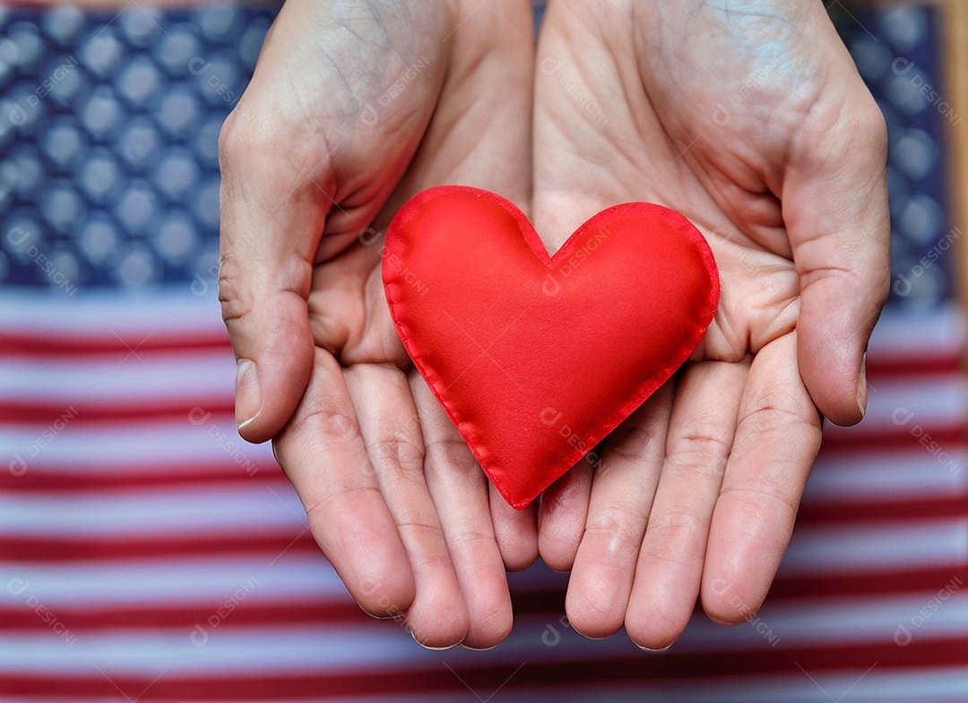 Mãos segurando um coração vermelho