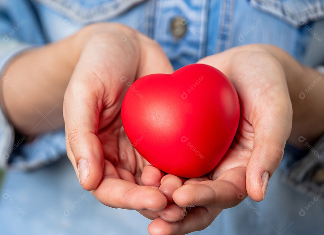 Mãos segurando um coração vermelho