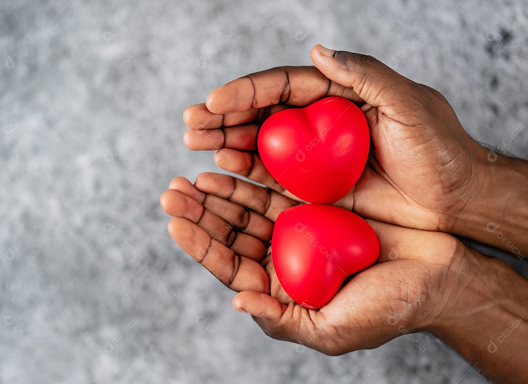 Mãos segurando um coração vermelho