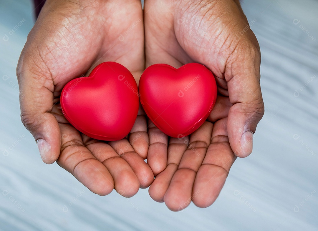 Mãos segurando um coração vermelho