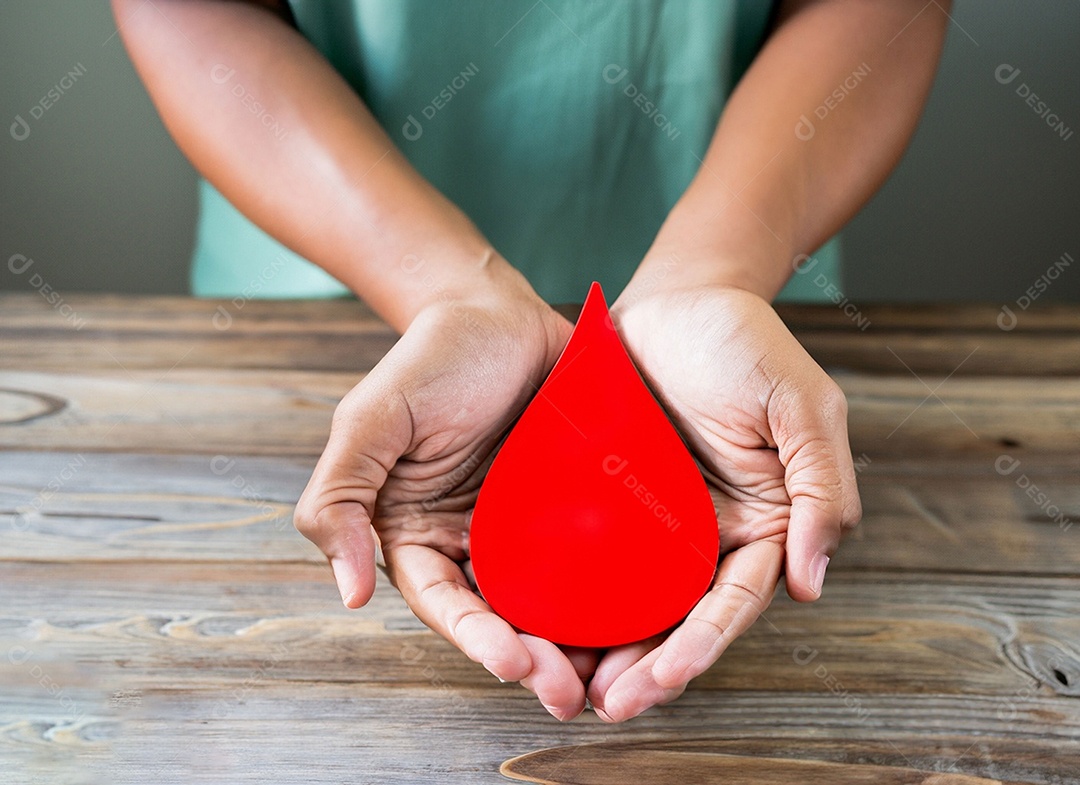Mãos segurando uma gota vermelha