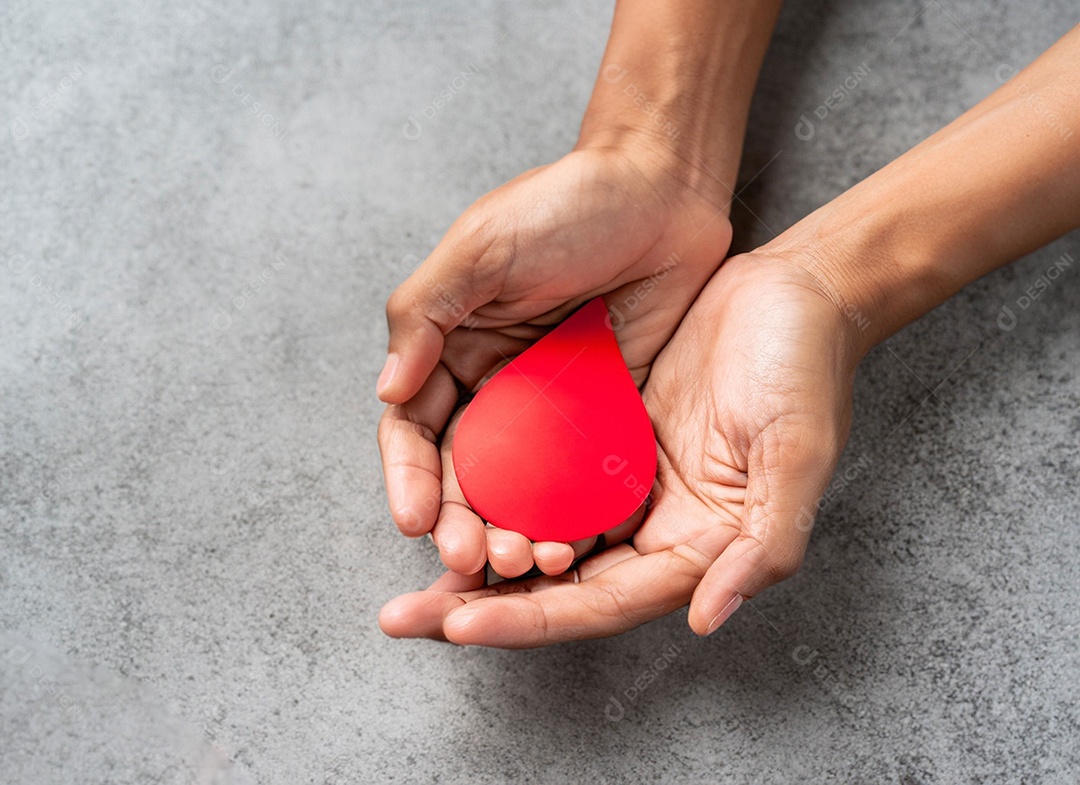 Mãos segurando uma gota vermelha