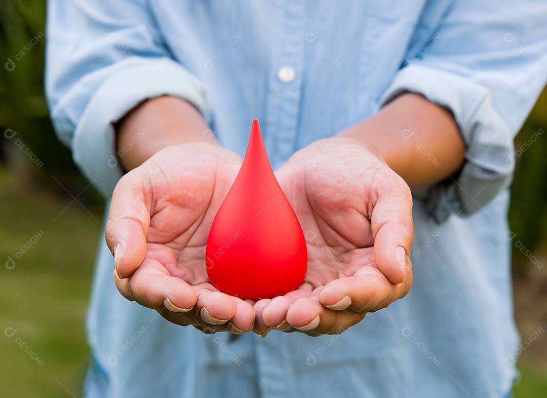 Mãos segurando uma gota vermelha