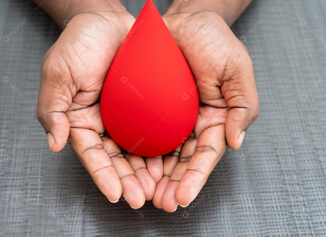 Mãos segurando uma gota vermelha