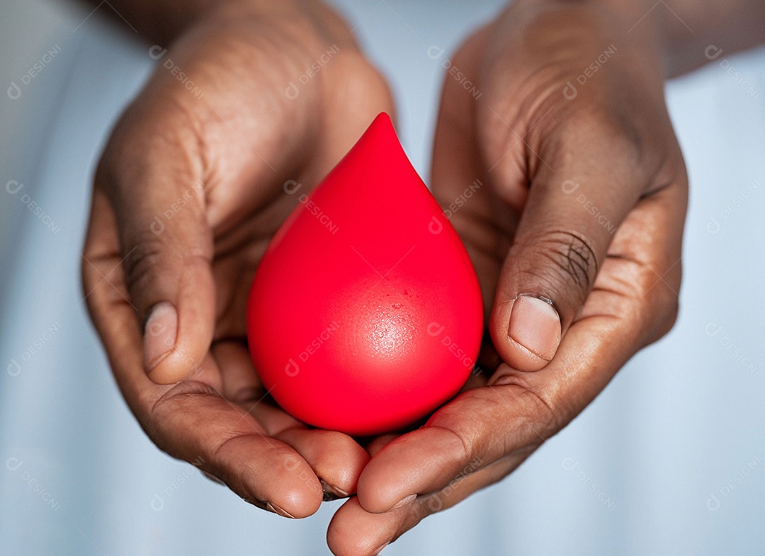 Mãos segurando uma gota vermelha
