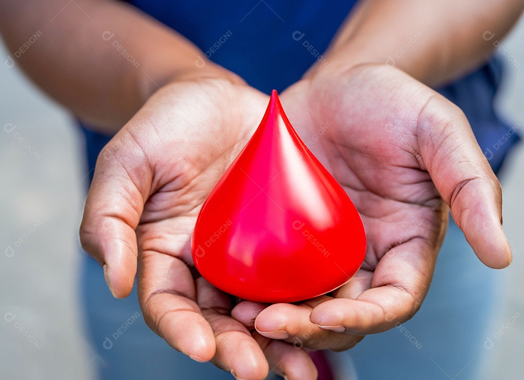 Mãos segurando uma gota vermelha