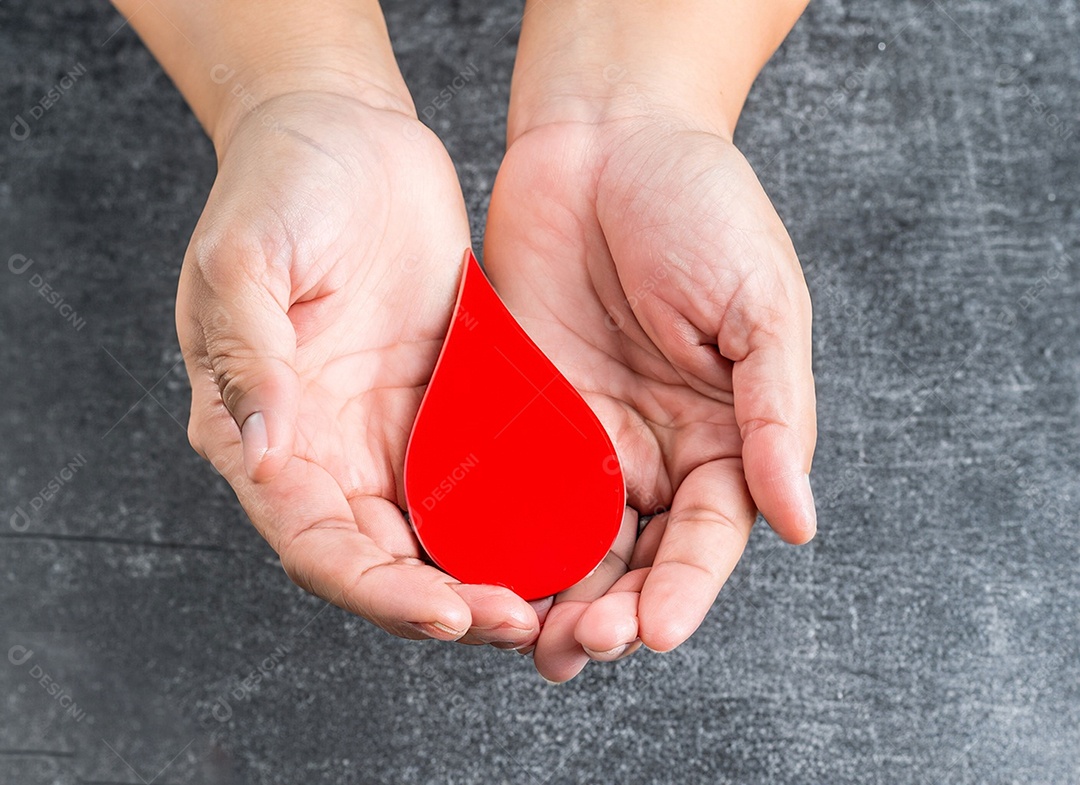 Mãos segurando uma gota vermelha