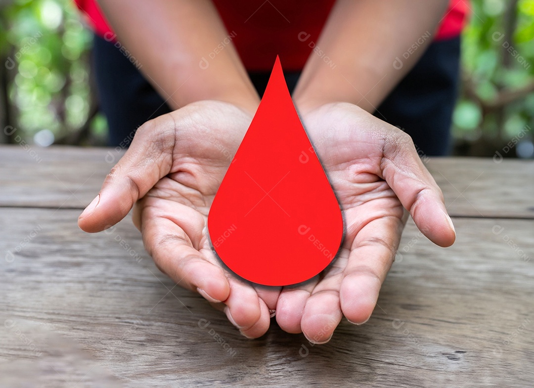 Mãos segurando uma gota vermelha