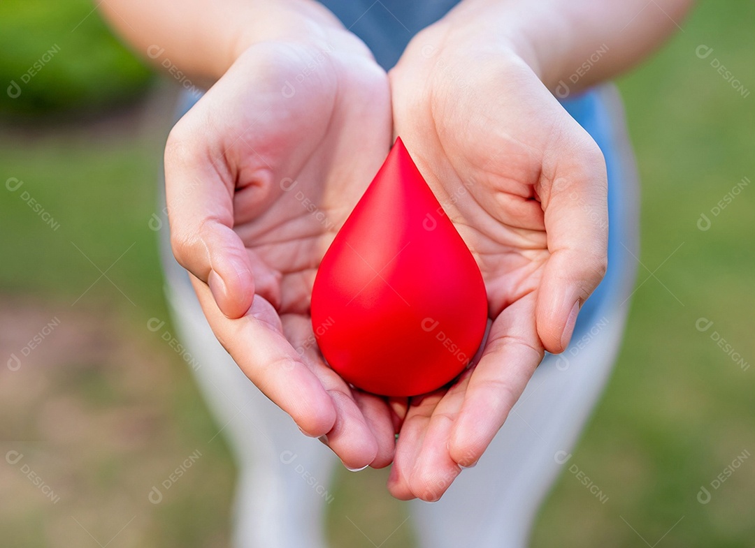 Mãos segurando uma gota vermelha