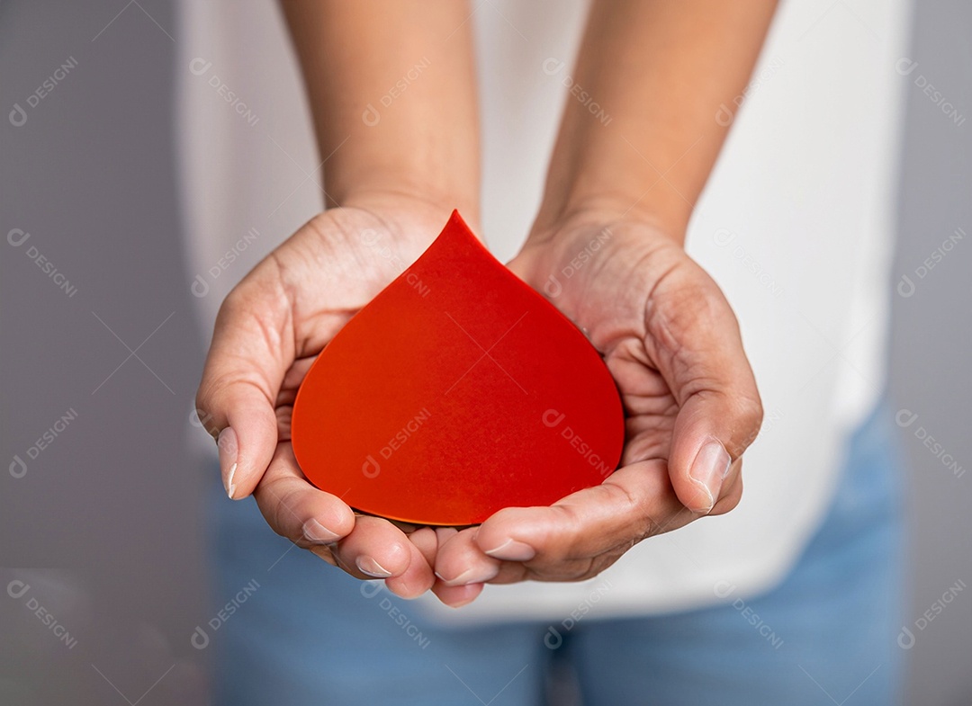Mãos segurando uma gota vermelha